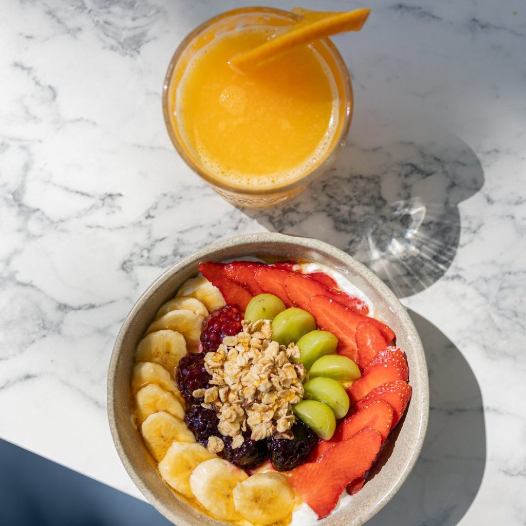 Bol de fruta fresca con zumo de naranja natural para desayunar en Simbad